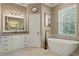 Spa-like bathroom with a standalone tub, and stone tiled floors at 5017 Muir Way, Lithia, FL 33547