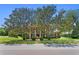 Charming brick home with mature trees, manicured lawn, and classic architectural details at 5017 Muir Way, Lithia, FL 33547
