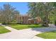 Stately brick home with manicured lawn and mature trees creating a sense of arrival at 5017 Muir Way, Lithia, FL 33547