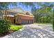 Brick home featuring a 3 car garage and driveway at 5017 Muir Way, Lithia, FL 33547
