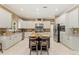 Gourmet kitchen featuring an island with seating, white cabinets, stainless steel appliances, and a tiled floor at 5017 Muir Way, Lithia, FL 33547