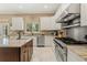 Kitchen featuring an island, stainless steel appliances, white cabinets and granite countertops at 5017 Muir Way, Lithia, FL 33547