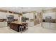 Large kitchen showcasing an island with bar stools, white cabinets, stainless appliances and tiled floors at 5017 Muir Way, Lithia, FL 33547