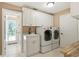 Bright laundry room featuring white cabinets, a sink, and modern washer and dryer set at 5017 Muir Way, Lithia, FL 33547