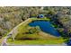 Aerial shot of a pond with walking trail and a home in a wooded setting at 5017 Muir Way, Lithia, FL 33547