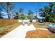 Inviting backyard features a patio with seating, a manicured lawn, mature landscaping and a small above ground pool at 5365 Flamingo Dr, St Petersburg, FL 33714