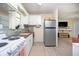 Compact kitchen features stainless steel appliances, stylish backsplash, and access to living area at 5365 Flamingo Dr, St Petersburg, FL 33714