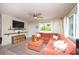 Cozy living room features a large sectional sofa, stylish decor, and large windows that provide plenty of natural light at 5365 Flamingo Dr, St Petersburg, FL 33714