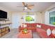 Cozy living room featuring stylish furnishings, including a comfy sectional and decor, complemented by natural light and wood-look flooring at 5365 Flamingo Dr, St Petersburg, FL 33714