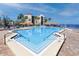 Beautiful community pool area with tiki umbrellas, lounge chairs, and lush tropical landscaping at 5736 La Puerta Del Sol S Blvd # 254, St Petersburg, FL 33715