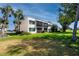 Exterior view of a condo building with lush green lawn and mature trees at 5736 La Puerta Del Sol S Blvd # 254, St Petersburg, FL 33715