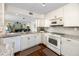 Charming kitchen with white cabinetry, granite counters, stainless appliances, and hardwood floors at 5736 La Puerta Del Sol S Blvd # 254, St Petersburg, FL 33715
