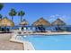 Inviting pool area with sun shades and lounge chairs overlooking the water on a sunny day at 5736 La Puerta Del Sol S Blvd # 254, St Petersburg, FL 33715