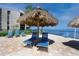 Relaxing poolside lounge area with tiki umbrellas and blue lounge chairs overlooking the water at 5736 La Puerta Del Sol S Blvd # 254, St Petersburg, FL 33715