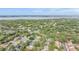 Wide aerial shot of neighborhood with mature trees and landscaping, with lake visible in the distance at 614 Fayette S Dr, Safety Harbor, FL 34695