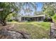 Spacious backyard featuring a screened-in porch, a lush green lawn, and mature trees at 614 Fayette S Dr, Safety Harbor, FL 34695