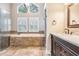 Bathroom with a large window, a bathtub with stone siding, glass shower, and a dual sink vanity at 614 Fayette S Dr, Safety Harbor, FL 34695