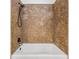 Bathroom featuring a shower with stacked stone detail and white tub at 614 Fayette S Dr, Safety Harbor, FL 34695