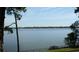 Calm waterfront view with a grassy bank leading to a protective fence, set against a serene and tranquil horizon at 614 Fayette S Dr, Safety Harbor, FL 34695