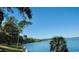 Expansive waterfront view featuring lush green foliage and a clear blue sky reflecting in the tranquil water at 614 Fayette S Dr, Safety Harbor, FL 34695