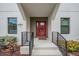 Inviting entryway with a vibrant red door, sleek railings, and well-maintained landscaping at 6904 S Macdill Ave # 1, Tampa, FL 33611