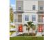 Modern townhome showcases clean lines, black framed windows, balcony, and vibrant red doors at 6904 S Macdill Ave # 1, Tampa, FL 33611