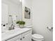 Clean and simple half bathroom with a white vanity, modern fixtures, and a decorative painting on the wall at 7023 Montauk Point Xing, Bradenton, FL 34212