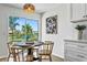 Cozy dining area with a round table, modern lighting fixture, and a view of the backyard and waterway at 7023 Montauk Point Xing, Bradenton, FL 34212