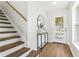 Welcoming entryway with wood floors, staircase, decorative table, and a front door with decorative glass at 7023 Montauk Point Xing, Bradenton, FL 34212