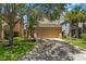 Charming two-story home with a tan exterior, attached garage, mature trees, and landscaped front yard at 7023 Montauk Point Xing, Bradenton, FL 34212