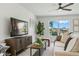 Comfortable living room featuring stylish decor, a large TV, and a window with a view of the community waterway at 7023 Montauk Point Xing, Bradenton, FL 34212