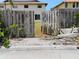 View through an opening in the fence to the backyard with access to the home through glass doors at 7085 Sunset S Dr # A, St Petersburg, FL 33707
