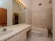 Bathroom featuring vanity with drawers, tiled floors, toilet and a built-in bathtub at 7085 Sunset S Dr # A, St Petersburg, FL 33707