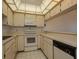 Bright eat-in kitchen featuring all appliances, light cabinetry and a unique ceiling light panel at 7085 Sunset S Dr # A, St Petersburg, FL 33707