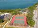 Aerial view of community tennis courts near the water, perfect for active recreation and enjoying waterfront views at 7085 Sunset S Dr # A, St Petersburg, FL 33707