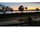 Scenic water view featuring palm trees silhouetted against a beautiful sunset sky at 7085 Sunset S Dr # A, St Petersburg, FL 33707