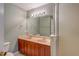 Bathroom featuring double sink vanity, a large mirror, and wood cabinets at 8531 Trail Wind Dr, Tampa, FL 33647