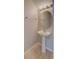 This bathroom is equipped with a pedestal sink, oval mirror, chrome towel rack, and neutral decor at 8531 Trail Wind Dr, Tampa, FL 33647