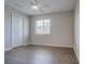 Bright bedroom features hardwood floors, closet, and a ceiling fan with attached lighting at 8531 Trail Wind Dr, Tampa, FL 33647