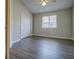 This bedroom offers wood floors, a ceiling fan, and a window for natural light at 8531 Trail Wind Dr, Tampa, FL 33647