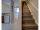Hallway with staircase and tile floors with a view to the kitchen and a sliding glass door at 8531 Trail Wind Dr, Tampa, FL 33647