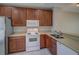 Kitchen featuring white appliances, wooden cabinets, and a stainless steel sink at 8531 Trail Wind Dr, Tampa, FL 33647