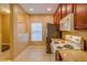 Well-lit kitchen featuring stainless steel refrigerator, white microwave, wood cabinets and tile floor at 8531 Trail Wind Dr, Tampa, FL 33647