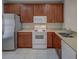 Kitchen boasts stainless steel refrigerator, white microwave, white oven, and wood cabinets at 8531 Trail Wind Dr, Tampa, FL 33647