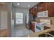 Kitchen area with stainless steel refrigerator, white appliances, and brown cabinets at 8531 Trail Wind Dr, Tampa, FL 33647