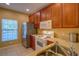 Kitchen featuring stainless steel refrigerator, white microwave, wood cabinets and tile floor at 8531 Trail Wind Dr, Tampa, FL 33647