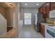 Open kitchen with stainless steel fridge, white oven, tile floor, and a window with natural light at 8531 Trail Wind Dr, Tampa, FL 33647
