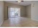 Large living room with tile flooring, ceiling fan, and access to a private patio at 8531 Trail Wind Dr, Tampa, FL 33647