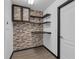 Laundry room featuring decorative brick, hanging wall shelves, and wood-look tile flooring at 9644 Jasmine Brook Cir, Land O Lakes, FL 34638