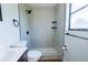 Modern bathroom featuring a tiled walk-in shower with black fixtures and mosaic tile flooring at 9706 N 22Nd St, Tampa, FL 33612